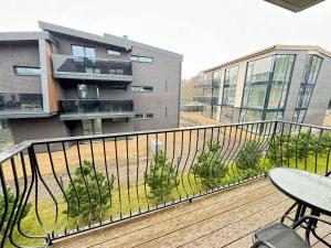 un balcon avec une terrasse en bois avec un bâtiment dans l'établissement Palanga Ajerų Apartments, à Palanga