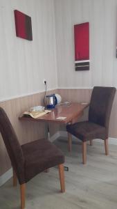 a wooden table with two chairs and a lamp on it at Haus Barnabas im Engel, Gasthaus Engel in Utzenfeld