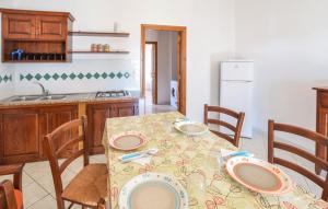 a kitchen with a table and chairs with plates on it at Appartamenti a Sa Serra di Orosei in Orosei