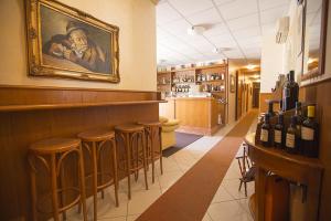 a bar with a painting on the wall and stools at Albergo La Principessa in Alcamo