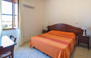 a bedroom with an orange bed and a window at Appartamenti a Sa Serra di Orosei in Orosei