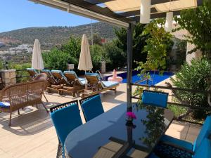 Un patio con sillas, mesa y sombrilla. en Villa lady Detached villa with sea view, en Kalkan