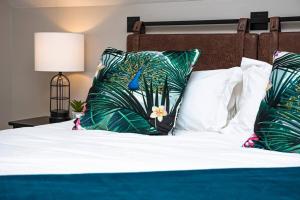 a bed with green and white pillows on it at It's All Good - Two Homes Sleeps 18 in Indianapolis