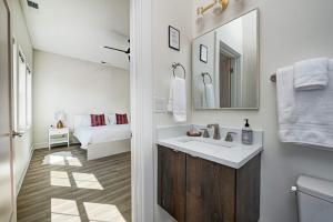 a bathroom with a sink and a mirror and a bed at It's All Good - Two Homes Sleeps 18 in Indianapolis +91 photos