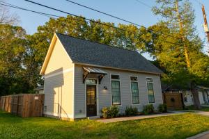 a small white house with a black roof at The Blue Heron Haven in Baton Rouge