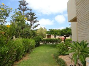 a garden outside a house with trees and plants at Villa at Karawan Resort in Al Ḩammām