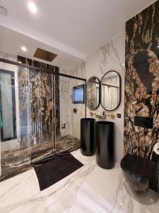 a bathroom with two circular mirrors and a black tub at California Baïa Bandol Villa in Bandol