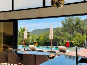 a dining room with a view of a swimming pool at California Baïa Bandol Villa in Bandol