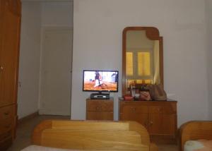 a living room with a television and a mirror at Villa at Karawan Resort in Al Ḩammām