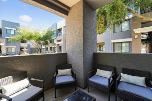 a balcony with chairs and a wall with buildings at Chic 1BR at Westgate Pool, Gym & Stadium Fun apts in Shamrock Mobile Home Park +27 photos