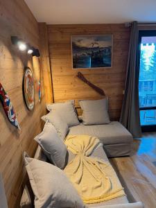 a bedroom with two beds in a room with wooden walls at Studio Mbs Pra Loup in Pra-Loup