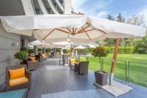 a patio with tables and chairs under umbrellas at Eurostars Monte Real in Madrid