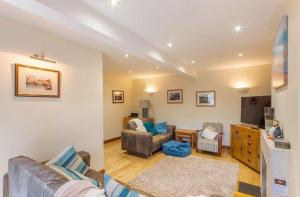 ein Wohnzimmer mit Sofa und Fernseher in der Unterkunft Puffin Cottage, Bamburgh in Bamburgh