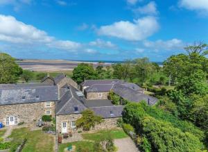 eine Luftansicht eines Hauses mit Bäumen in der Unterkunft Puffin Cottage, Bamburgh in Bamburgh
