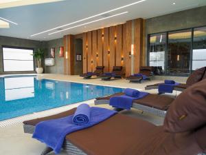 a swimming pool with lounge chairs and blue towels at Shirvan Grand Hotel Shamakhi in Shamakhi