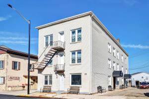 a white building with a staircase on the side of it at Newly renovated-across the street from Von Stiehl! in Algoma