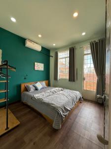 ホーチミン・シティにあるDuctaigallery's Entire Apt- Near Bui vien stの緑の壁のベッドのある寝室