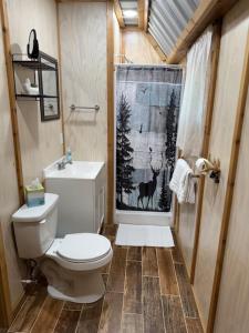 a bathroom with a toilet and a deer shower curtain at Trails , Tails , and Scales Cabin 2 in Burkeville +38 photos