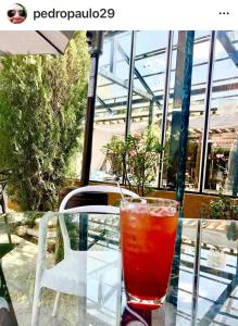 a drink sitting on a glass table in front of a building at Relais Amadeus Pousada de Charme in Pirenópolis +55 photos