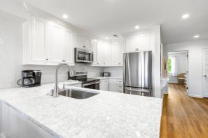 a kitchen with white cabinets and a stainless steel refrigerator at Mariner's Walk 5F - Ocean View Condo! Pool! in Isle of Palms