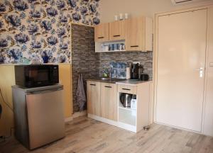 a small kitchen with a stove and a microwave at De Rozenhof in Groningen