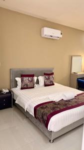 une chambre avec un grand lit avec des oreillers rouges dans l'établissement Residencial DB, à Luanda
