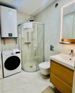 a bathroom with a shower and a toilet and a sink at Superb Old Town Apartment in Klaipėda