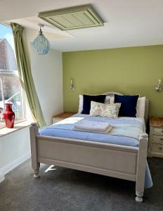 a bedroom with a bed with blue sheets and a window at The Mansion House Hotel in Holbeach