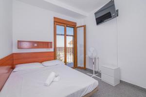 a bedroom with a white bed with white towels on it at Casa de las Nieves in Granada