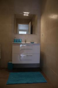 a bathroom with a sink and a mirror at Apartment House in Costa da Caparica