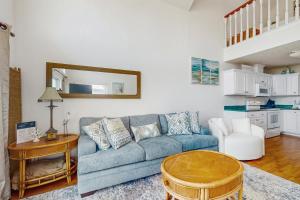 a living room with a blue couch and a table at Lofty Views in Indian Pass