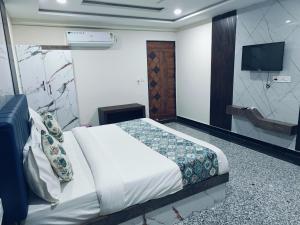 une chambre avec un lit et une télévision dans l'établissement Hotel jmm s14, à Udaipur