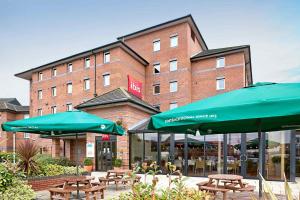 a restaurant with tables and umbrellas in front of a building at ibis Liverpool Centre Albert Dock – Liverpool One in Liverpool