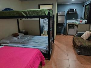 a bedroom with a bunk bed and a kitchen at Granja Agua Azul, Wi-FI,AC-WC,Parking,la Fortuna in Fortuna