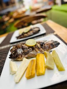 une assiette de nourriture avec un poisson au citron dans l'établissement Residencial DB, à Luanda 19 autres photos