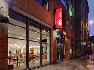 una tienda frente a un edificio de ladrillo con un restaurante en ibis Manchester Centre 96 Portland Street, en Mánchester