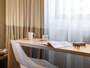 a desk with a chair and a book and a cup at ibis Manchester Centre Princess Street in Manchester