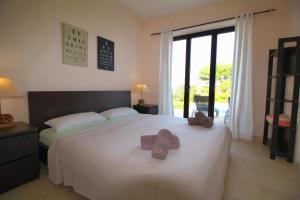 a bedroom with a bed with two teddy bears on it at Libertas Cala Llombards Blue Lagoon in Cala Llombards