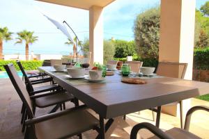 a wooden table with chairs and a tableasteryasteryasteryasteryasteryasteryasteryastery at Libertas Cala Llombards Blue Lagoon in Cala Llombards