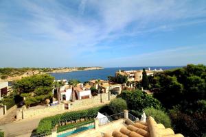 an aerial view of a village and the ocean at Libertas Cala Llombards Blue Lagoon in Cala Llombards