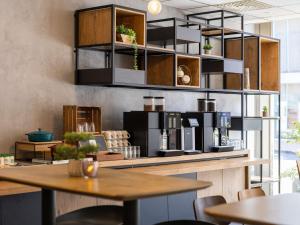 Una cocina con un mostrador con una mesa y estantes. en Ibis Namur Centre, en Namur