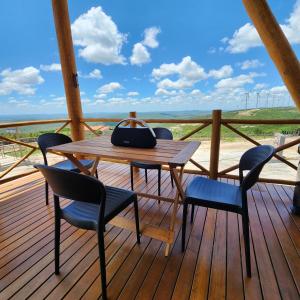 a wooden table and chairs on a wooden deck at Chalé Vivenda dos Ventos in Serra de São Bento