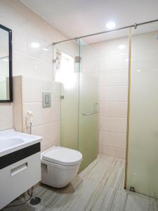 a bathroom with a toilet and a glass shower at Stay Pride Service Apartments - AC Rooms in Vijayawada - Family & Business Stays in Vijayawāda