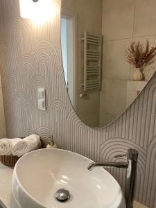 a bathroom with a sink and a mirror at Apartament Avangarda in Opole