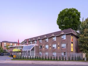 a large brick building on the corner of a street at Super 8 by Wyndham Toronto East ON in Toronto