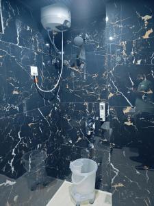 une salle de bain avec un mur en marbre noir avec des toilettes dans l'établissement Hotel jmm s14, à Udaipur