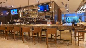 a bar in a restaurant with chairs around it at Global Hotel Panama in Panama City