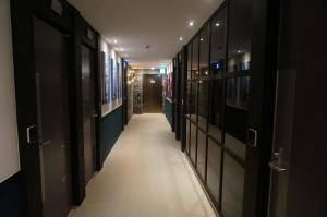 a hallway with black doors and white tile floors at MU Hotel in Busan