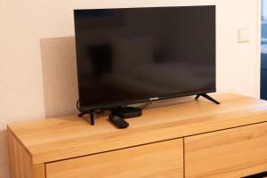 a flat screen tv sitting on top of a dresser at Studio 17 FeWo Schwaigern in Schwaigern