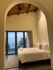 a bedroom with a bed and a large window at Barland Villa in Ke Ga
